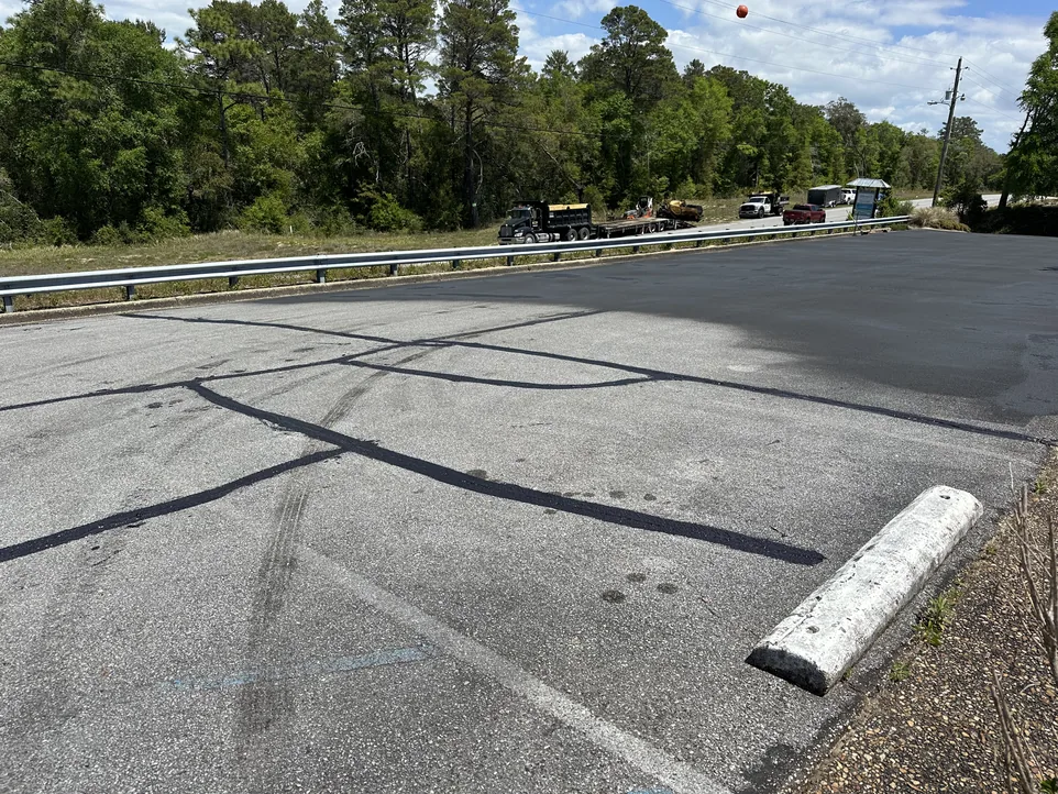 Sealcoating with crack sealing in progress