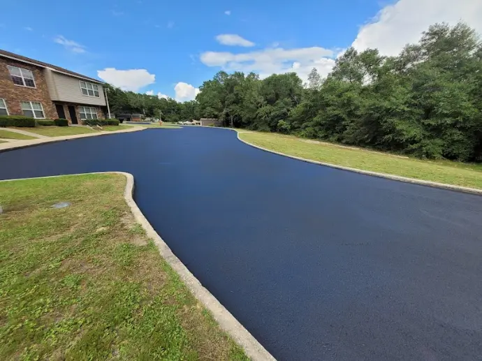 Fresh sealcoated asphalt driveway with a deep black finish