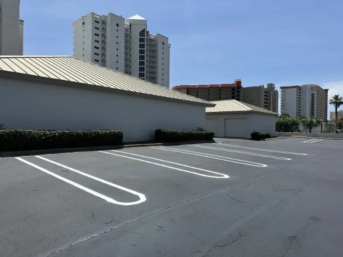Fresh white parking lot striping near coastal buildings